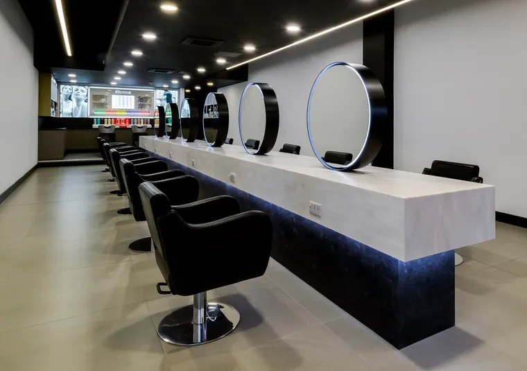 The Room 97 styling floor — black chairs, white stone bar and round halo mirrors